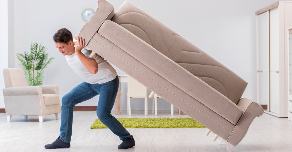 A man moving a couch by himself