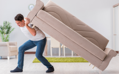 A man moving a couch by himself